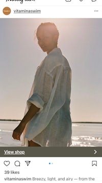 a woman in a white shirt is standing on the beach